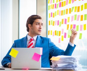 Young handsome employee with many conflicting priorities