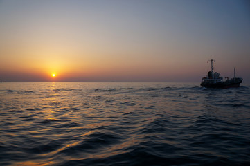 Fototapeta na wymiar beautiful sunrise and ship on sea 