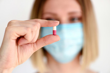 Young attractive woman holding a pill to be taken to her patient. Healthcare and medical concept.