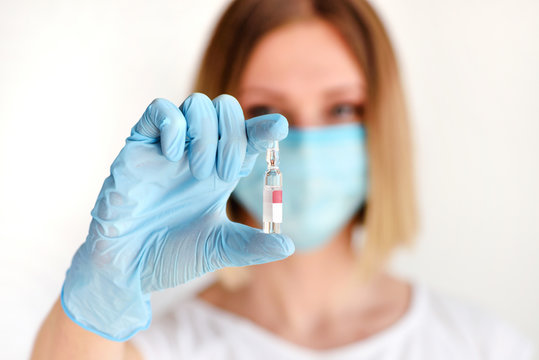 Nurse or doctor holding a ampule of medicine for patient. Vaccination, prevention, immunization and treatment. Health care in hospital.