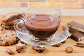 Cup of hot chocolate among the nuts and confections closeup