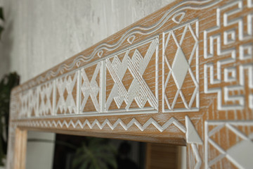 Close up view of the corner of an intricate classic design mirror