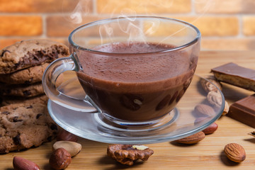 Cup of hot chocolate among the nuts and confections closeup