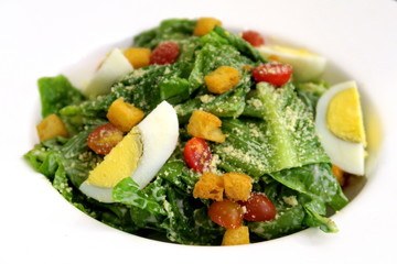 Salade césar dans une assiette blanche.