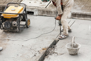 Construction worker using jackhammer drilling concrete surface