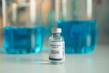 Close-up on Laboratory Tube Virus corona covid 19 vaccine. Scientist research for new novel corona virus immunization drug concept. Coronavirus COVID-19 vaccine vial and injection syringe.