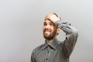 Closeup portrait, goofy, silly young man, slapping hand on head . Negative human emotion facial...