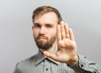 Closeup portrait of surprised helpless young man raising hand up to say no stop right there,...