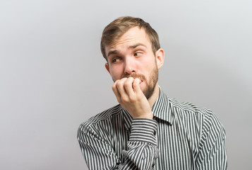 Closeup portrait of thinking man with finger in mouth, sucking thumb, biting fingernail in anxiety, stress, deep in thought, isolated on white background. Negative emotion, facial expression, feelings - 345541020