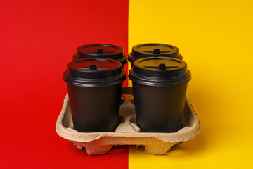 Black take away coffee cups in holder on table