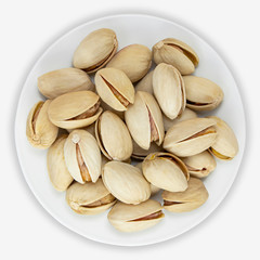 Pistachio nuts on a white plate. Isolated background. View from above.