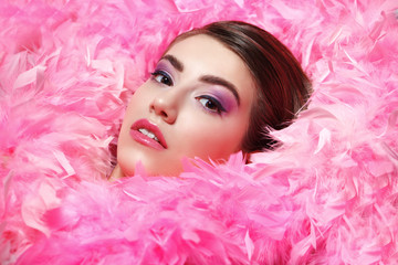 face surrounded by fluffy pink boa