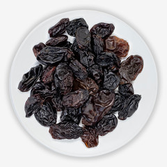 Dark grape raisins on a white plate. Isolated background. View from above.