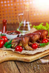 Barbecue fried quail carcasses with on orange with tomatoes and fresh parsley, on a wooden background