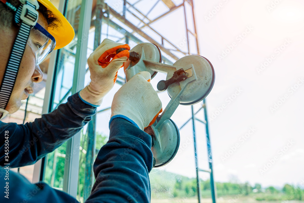 Aufkleber close up technician worker at window installation in building construction site.