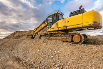 Excavator moving gravel at a construction site