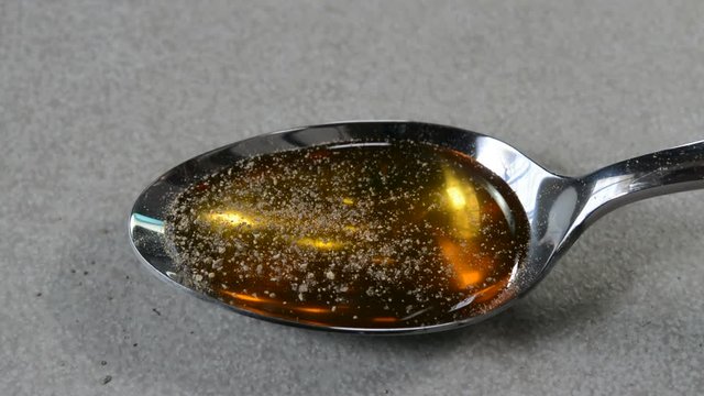 Adding black pepper with honey in a table spoon