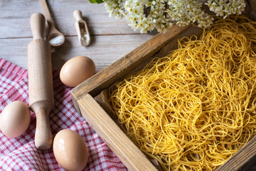 Making vermicelli with pasta machine on a wooden background