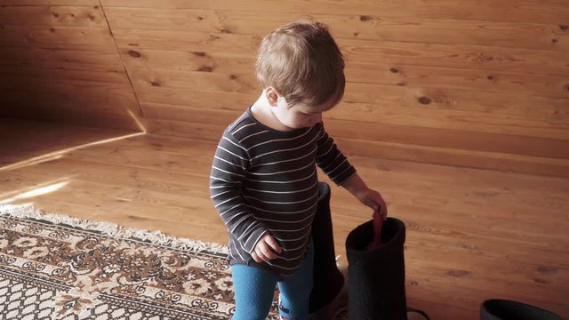 Boy plays with woolen boots