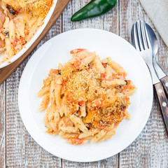 Mac and cheese with mini penne pasta, on white plate, closeup, top view, square format