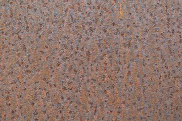 Rusty metal plate background with little orange spot