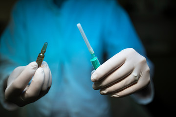 Nurse holding a Syringe and a vaccine container.