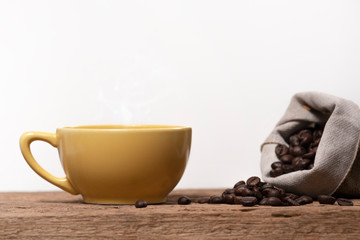 cup of coffee with coffee beans in sackcloth on wood table