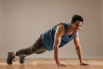 Man doing push ups over a plain background. 
