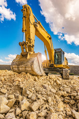 Excavator in a quarry extracting stone