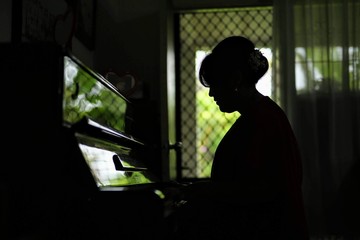 woman playing old piano