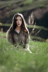 beautiful girl on the green hills during sunset