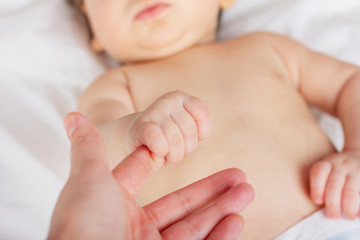 Newborn child. Children's hand holds a female hand. Maternity hospital.