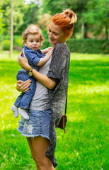 Portrait of a young mom and baby outdoors. Happy family. 