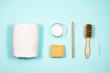 Zero waste concept. Toothbrush, tooth powder, towel, soap and brushes on a blue background. View from above.