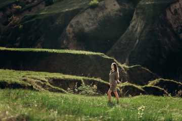 beautiful emotional girl on green saturated hills