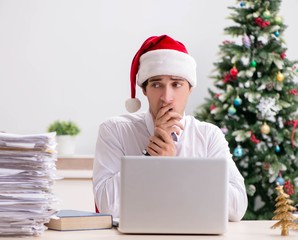 Young worker working in office on christmas shift