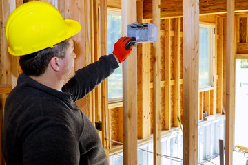 Installing electric sockets on the wall in new home new home construction