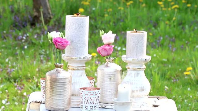 Flowers, candles and luxurious decorations on the table during a garden party.