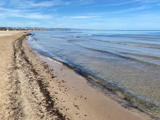 The cleanest sea on a city beach in Valencia, Spain. Clear water and blue sky. Сoastline