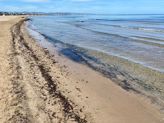 The cleanest sea on a city beach in Valencia, Spain. Clear water and blue sky. Сoastline