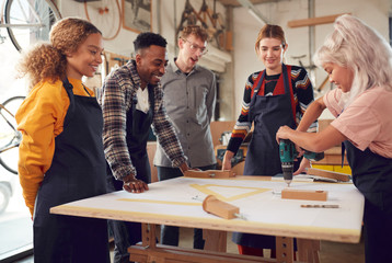 Multi-Cultural Team In Workshop Unpacking And Assembling Hand Built Sustainable Bamboo Bicycle Frame