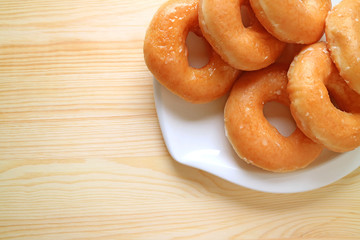 Top View of a Plate of Sugar-glazed Doughnuts on Wooden Table with Copy Space