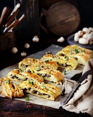 Homemade yeast pie with mushrooms on a dark wooden background, rustic style