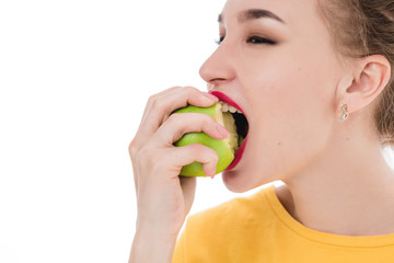 Emotional portrait of a girls who eat an apple on an isolated white background. The concept of a healthy diet, healthy lifestyle and vegetarianism