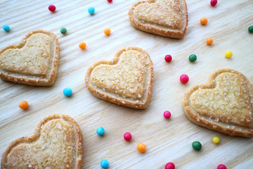 heart-shaped cookies, cutout cookies, heart shaped cookie, valentines desserts, shortbread biscuits, valentine's day cookies, valentines cookies, wooden board with colored sprinkles