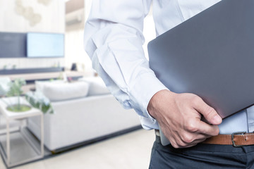 Businessman standing while carrying the laptop working from home