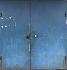 Old metal blue double door with peeling paint.