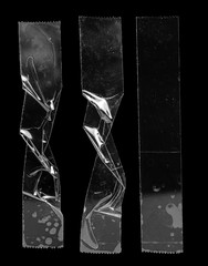 set of transparent adhesive tape or strips isolated on black background, crumpled plastic sticky snips, poster design overlays or elements for your cover idea.