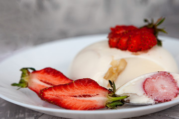 italian dessert panna cotta with fresh strawberries and a banana on a grey concrete background