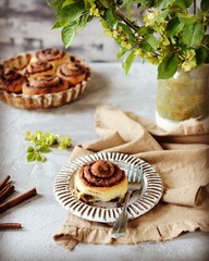 Cinnamon buns in a plate on a gray background, still life